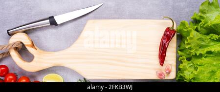 Cutting board on the table. Handmade chopping board. Fresh vegetables, spices and a cutting board. Stock Photo