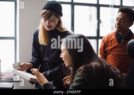 Female and male coworkers discussing over product in office Stock Photo