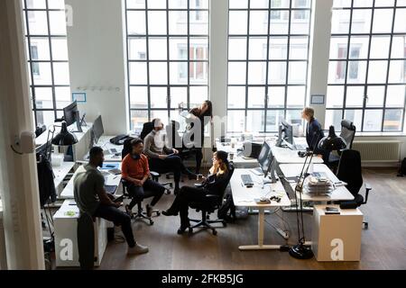High angle view of male and female professionals discussing during meeting in creative office Stock Photo