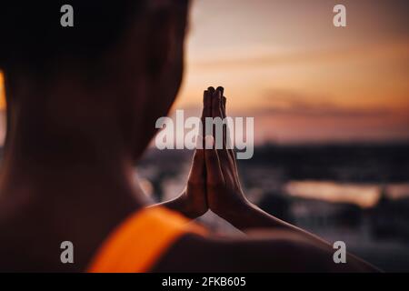 Female athlete practicing yoga during sunset Stock Photo