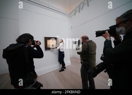 Gallery technician Anna Karabin at Sotheby's in London, during the unveiling of the earliest known sports painting by LS Lowry, Going to the Match, 1928, before it is offered at auction. Picture date: Friday April 30, 2021. Stock Photo