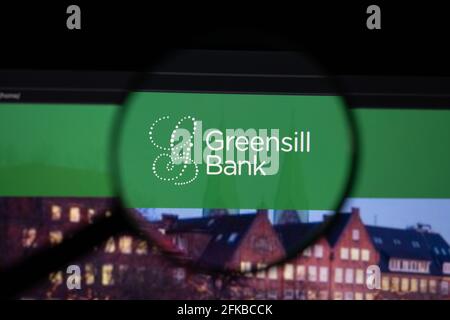 Greensill Bank company logo on a website with blurry stock market developments in the background, seen on a computer screen through a magnifying glass Stock Photo