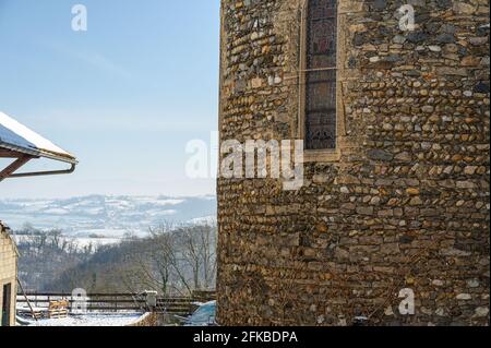 Old building wall made up of round rocks having a metal window Stock Photo