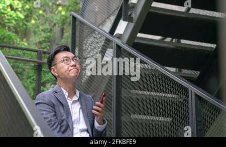 Asian businessman in suit with eyes looking up, thinking about something. Stock Photo