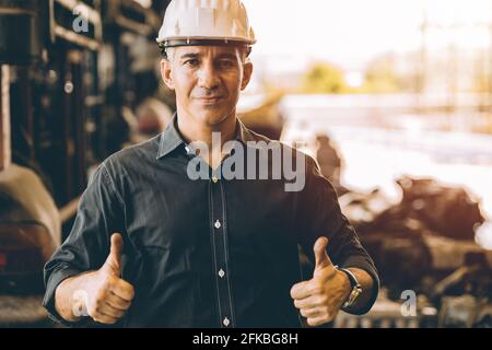 Professional adult Engineer male work in factory standing hands show two Thumbs up for good job or best working with confident smile Stock Photo