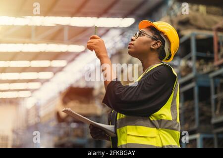 Black African professional women worker working count checking inventory production stock control in business factory  industry warehouse waring engin Stock Photo