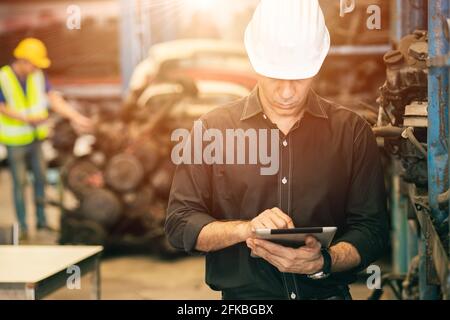 Professional adult Engineer male attending duty work in factory working checking stock inventory data with tablet computer Stock Photo
