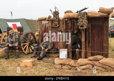 World War One reenactors dressed as German soldiers, by a reproduction of a trench shelter Stock Photo