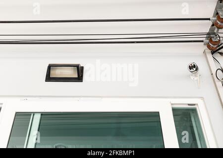 Lamps and CCTV mounted on the front wall of house. Stock Photo
