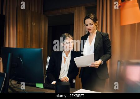 Businesswoman discussing over document with female lawyer at office Stock Photo