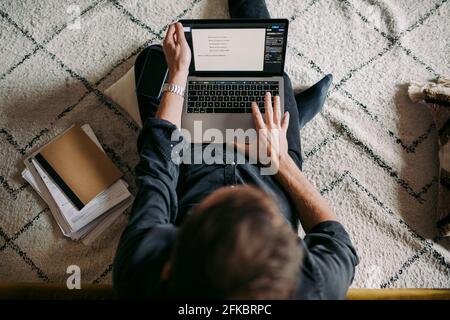 Directly above shot of businessman working on laptop at home Stock Photo