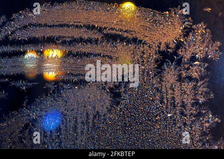 Frozen window glass in the night . Winter nighttime . Ice patterns on the glass Stock Photo