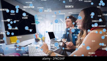 Network of bubbles with business technology words, over couple of businesspeople with laptop Stock Photo
