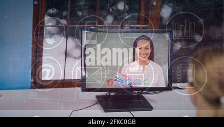 Composition of network of icons over businesswoman on computer video call screen Stock Photo