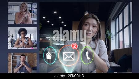 Composition of digital call icons over businesswoman on video call screen with work colleagues Stock Photo