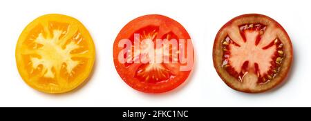 Sliced yellow, red and dark tomato isolated on white background, top view Stock Photo