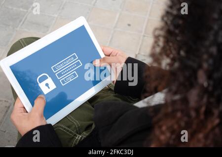 Close up of a girl using a tablet an enter her user and password.Security Concept. Stock Photo