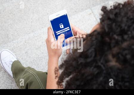 Close up of a girl unrecognizable entering her user a password on her phone. Security Concept. Stock Photo