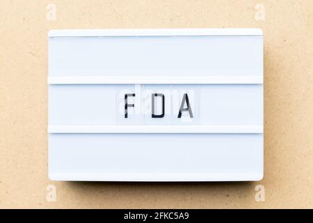 White lightbox with word FDA (abbreviation of food and drug administration) on wood background Stock Photo