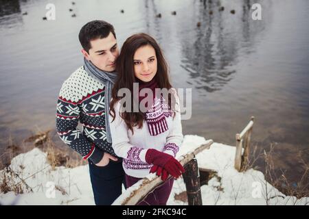 man and woman standing alone in winter forest near the river Stock Photo