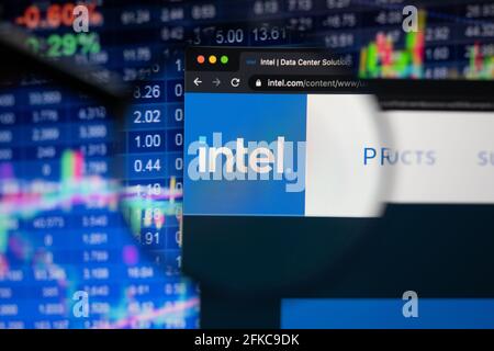 Intel company logo on a website with blurry stock market developments in the background, seen on a computer screen through a magnifying glass Stock Photo