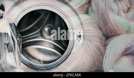 Opened washing machine and balls of yarn with copy space. Stock Photo