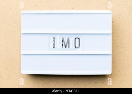 White lightbox with word IMO (Abbreviation of in my opinion) on wood background Stock Photo