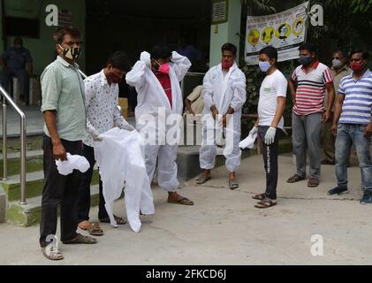Beawar, India. 30th Apr, 2021. Family members, wearing protective suits, perform last rites before the cremation of a COVID-19 victim at Hindu Moksha Dham crematorium, amid a surge in coronavirus cases in Beawar. (Photo by Sumit Saraswat/Pacific Press) Credit: Pacific Press Media Production Corp./Alamy Live News Stock Photo