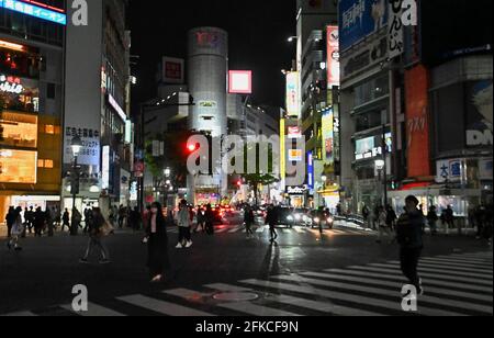 Tokyo, Japan. 30th Apr, 2021. Pedestrians wearing face masks walk at Shibuya crossing in Tokyo, Japan on Friday, April 30, 2021. Tokyo Governor Yuriko Koike request to turned off the neon signs after 8 PM during the third state of emergency for COVID-19 on April 25 through May 11. Photo by Keizo Mori/UPI Credit: UPI/Alamy Live News Stock Photo