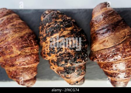 three croissants on a black tray top view Stock Photo