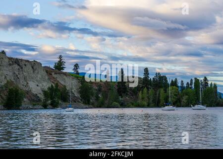 PENTICTON, CANADA - JULY 04, 2020: lake landscape with sailboats calm morning with cloudy sky. Stock Photo