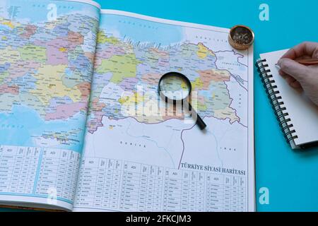 Turkey map on a book, Taking notes to a road trip preparations. A magnifying glass and a compass left side of the page. Stock Photo