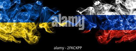 Ukraine, Ukrainian vs Russia, Russian smoky mystic flags placed side by side. Thick colored silky abstract smokes flags. Stock Photo