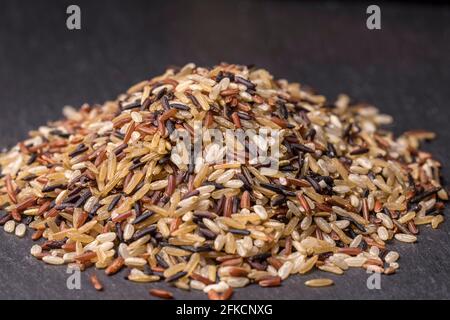 A small pile of raw uncooked wild rice in a studio setting. Stock Photo