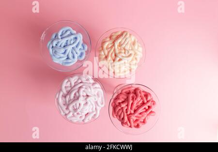 multicolored emulsions for cosmetic creams in glass on rose background, close up Stock Photo