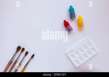 Aquarelle paint for painting. Painting brushes, colorful paints, and palette on white background. Copy space for Text. clipboard mockup. Artist Stock Photo