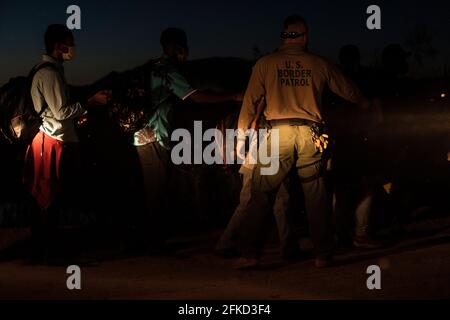 Yuma, Arizona, USA. 29th Apr, 2021. Asylum seekers are detained by U.S. Border Patrol at the border wall after crossing into the United States. Credit: Cheney Orr/ZUMA Wire/Alamy Live News