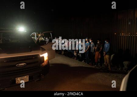 Yuma, Arizona, USA. 29th Apr, 2021. Asylum seekers are detained by U.S. Border Patrol at the border wall after crossing into the United States. Credit: Cheney Orr/ZUMA Wire/Alamy Live News