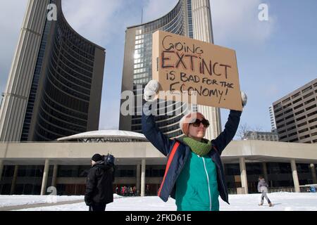 Toronto, Ontario, Canada - 03/01/2019: Young women hold placard to fight for climate change - Global warming and environment - Focus on the placard
