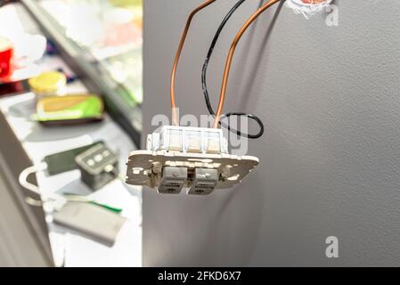The up and down shutter switch hangs on the cables protruding from the wall. Stock Photo