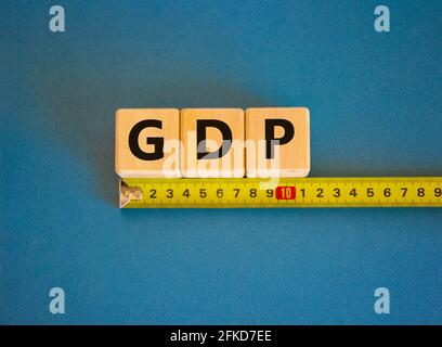 GDP, gross domestic product symbol. The word GDP, gross domestic product on cubes arranged behind the ruler on beautiful blue background. Copy space. Stock Photo