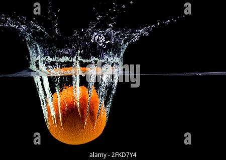 one green apple falling into water on a white background with splashes, drops and bubbles Stock Photo