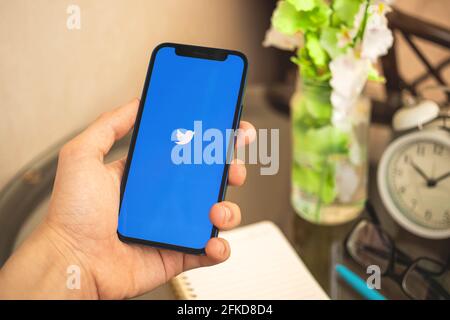 Kharkov, Ukraine - April 27, 2021: Man use Twitter social network app on Apple iPhone 12 Stock Photo