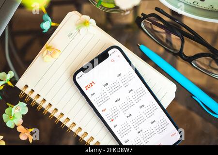 Kharkov, Ukraine - April 27, 2021: Calendar app on the screen of Apple iPhone, 2021 calendar close-up creative background photo Stock Photo