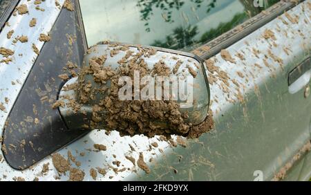 Dirty car side mirror car. The texture of dirt and dust on a metal close-up. Drops and splashes on a silver background. Stock Photo
