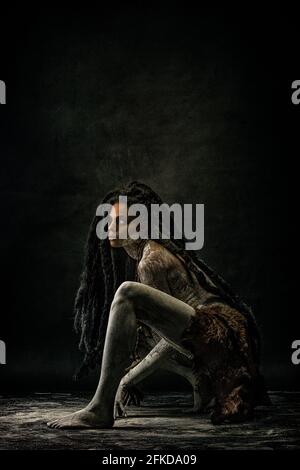 Young tribal woman covered in clay, wearing dreadlocks and bone necklaces Stock Photo