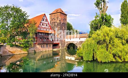 Nuremberg, Germany, beautiful old bridge with medieval tower and half timbered house along the river with reflections Stock Photo