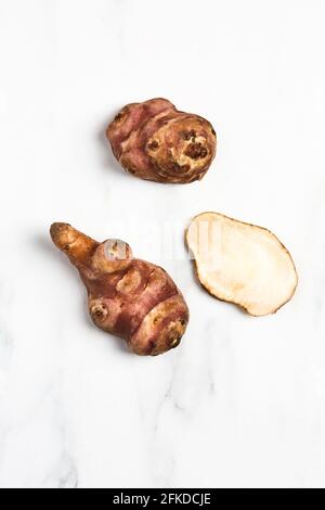 Overhead view of Jerusalem Artichokes on white marble Stock Photo