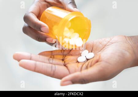 Pouring pills into hand Stock Photo