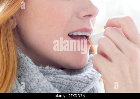Woman applying lip balm Stock Photo